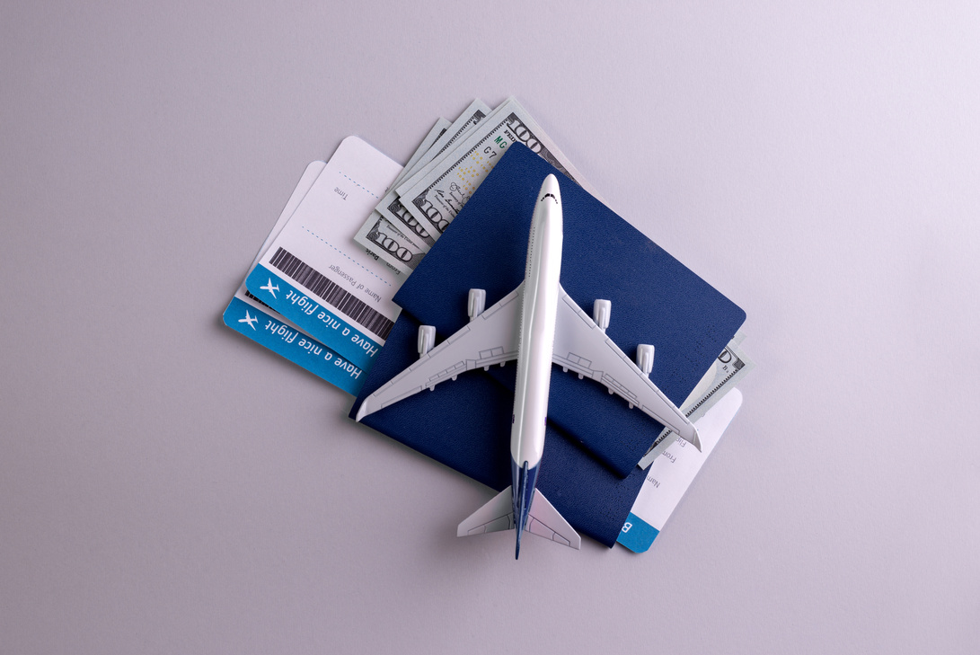 Flight Tickets with Passport and Plane Model Flatlay